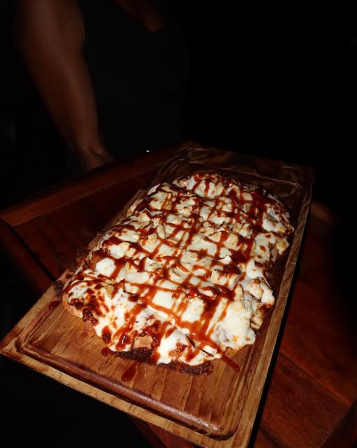 A flatbread served on a wooden board